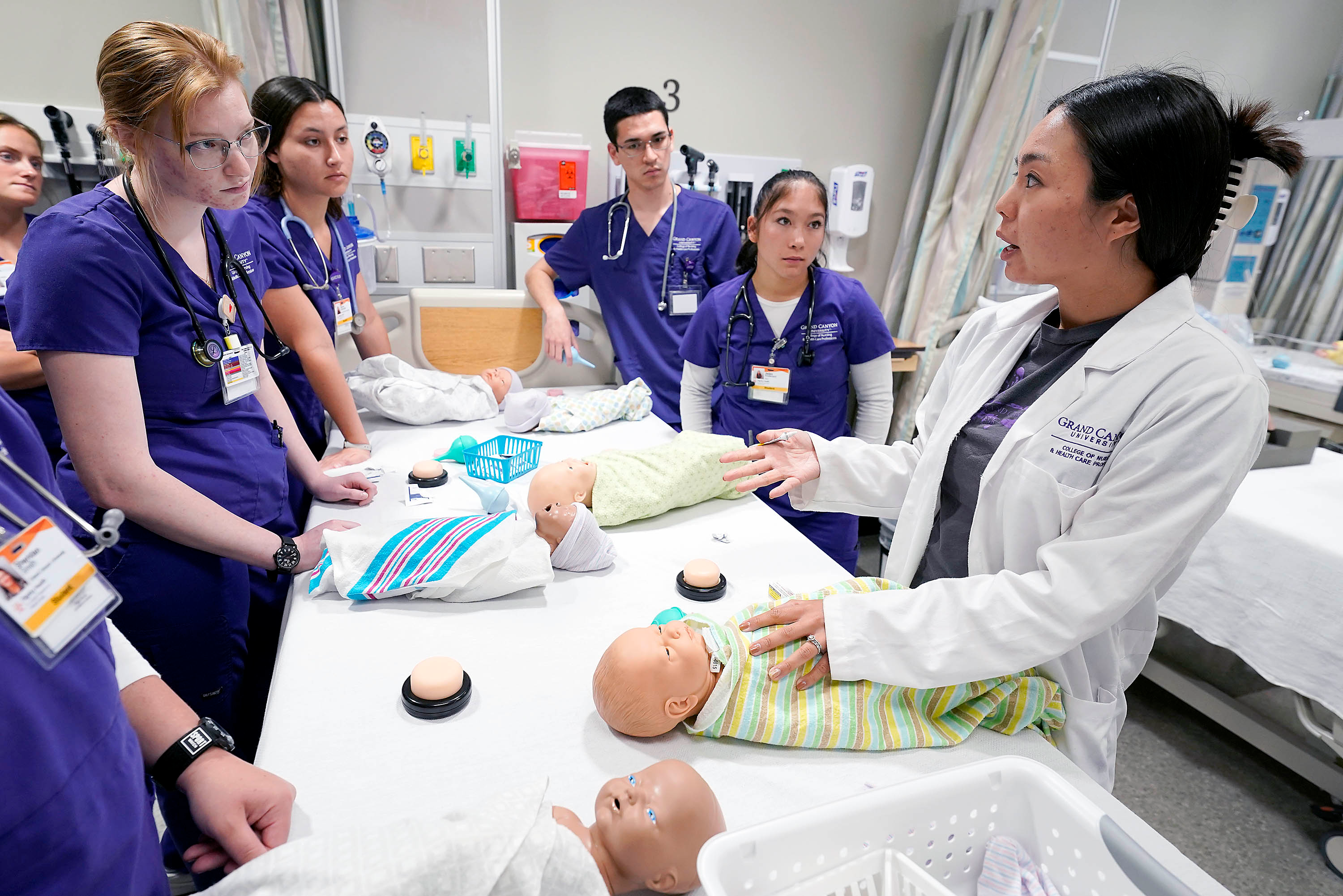 Nursing students learning how to care for infants in a clinical setting